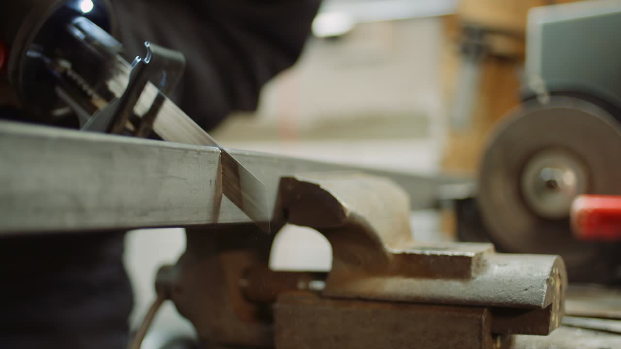 trabajador de la industria de piezas metálicas con sierra eléctrica