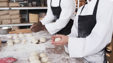 diverse bakers working in bakery kitchen, making rolls from dough in slow motion