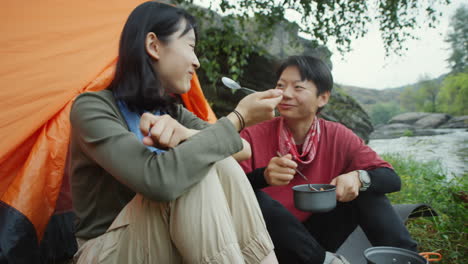 asian female tourists eating dinner at campsite