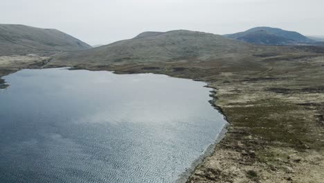 rotating and rising aerial view of spelga reservoir and mournes