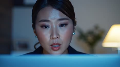 a woman with a concentrated expression engages with her computer late at night, surrounded by soft lighting and a serene atmosphere.