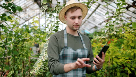 gardener using a tablet in a greenhouse