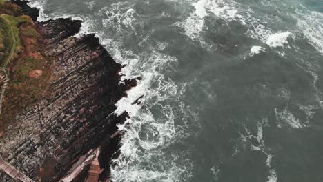 Aerial-view-of-rocky-cliffs-in-rippling-sea