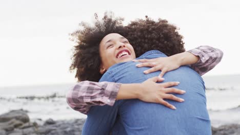 Mujer-Afroamericana-Abrazando-A-Su-Marido-En-Las-Rocas-Cerca-Del-Mar