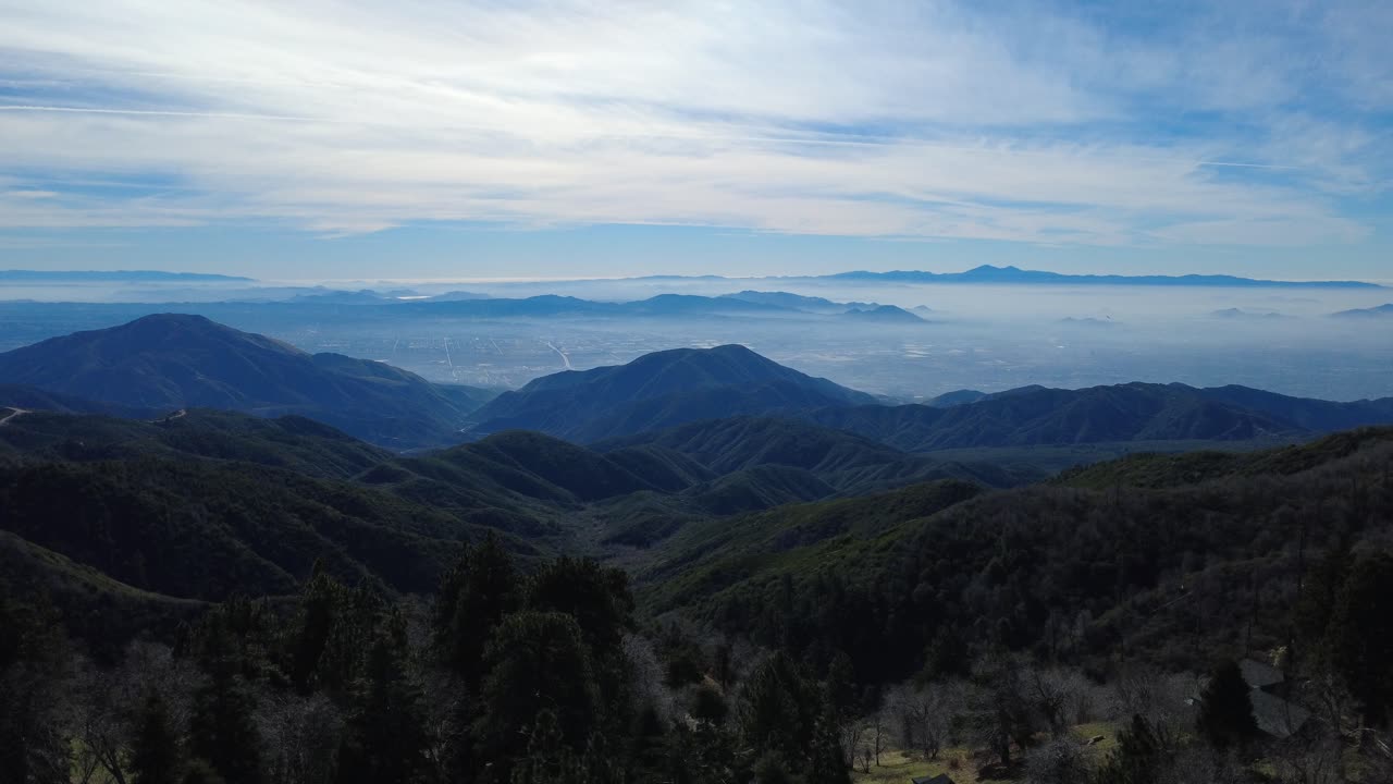 米国カリフォルニア州南部サンバーナーディーノ（インランド・エンパイア）の雄大な山頂からドローンが降下するパノラマビュー
