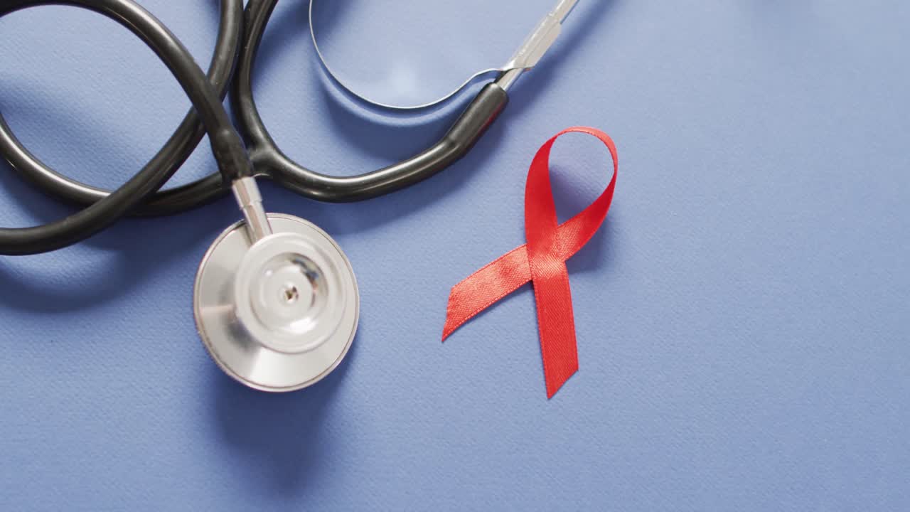 Vidéo d'un stéthoscope et d'un ruban rouge du cancer du sang sur fond bleu