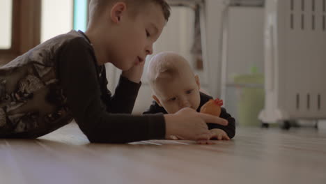 older brother playing with younger baby sister