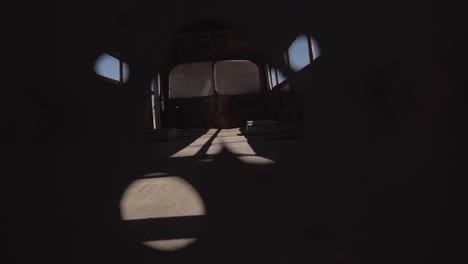 peeping through the hole of an abandoned bus in atacama desert, south america, chile