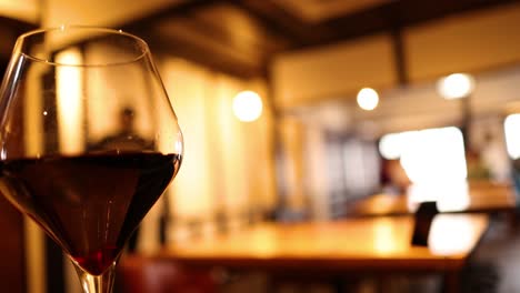 primer plano de una copa de vino rojo en un bar bien iluminado