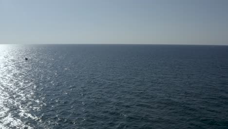 Aerial-wide-shot-of-a-single-motorboat-cross-the-sea-water,-drone-shot