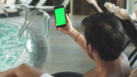 Closeup-handsome-man-having-video-call-with-green-screen-phone.-Man-with-phone