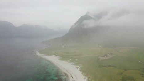 Drone-footage-of-Vik-Beach-and-Hauklandstranda-Norway,-coastline-aerial-shot-with-turquoise-blue-water-moving-through-clouds