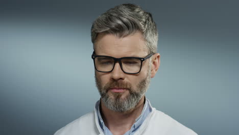 Close-Up-Of-The-Tired-Male-Doctor-With-Gray-Hair-Putting-Stethoscope-On-His-Neck-And-Taking-Off-Glasses-After-Hard-Working-Day