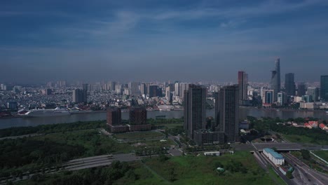 Aerial-panorama-Vietnam,-Ho-Chi-Minh-City-Skyline-panorama-on-sunny-clear-day-featuring-architecture,-Saigon-River,-Cruise-Ship-tunnel-entrance-and-port