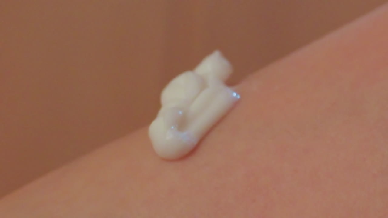 close up of hands applying moisturizing cream onto smooth leg skin, gentle circular massage motion enhancing skincare ritual, highlighting skin texture, soft lighting and personal care