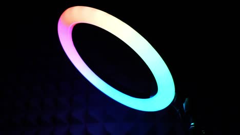 lámpara rgb de anillo luminoso. luz multicolor en una habitación oscura, primer plano.
