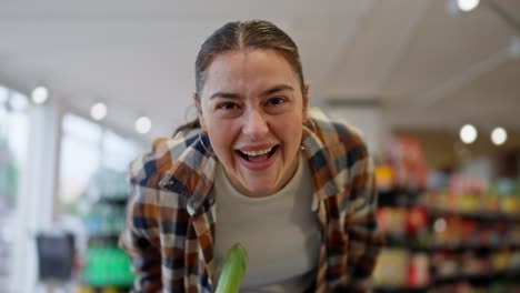 Portrait-of-a-happy-brunette-girl-in-a-plaid-shirt-who-runs-and-then-jumps-on-a-cart-and-rides-in-a-supermarket