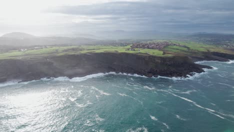 Cinematic-Shot-Of-Ajo-Village-Beautiful-Waterfront-With-Waves-Crashing-On-Shore,-Spain