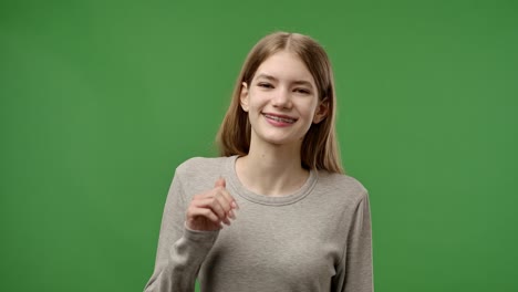 teenage girl smiling in front of green screen