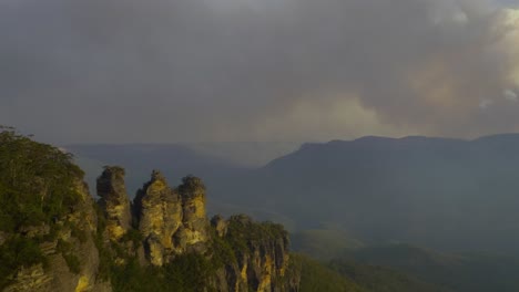 bushfire at echo point, three sisters over looking jamieson valley, blue mountains australia on windy hot day plume smoke static shot