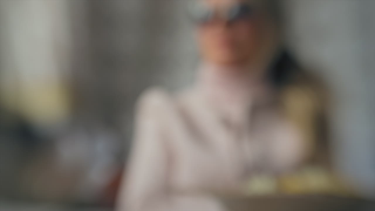 Blurred view of a brunette woman wearing sunglasses