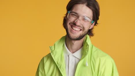 caucasian man in front of camera on yellow background.