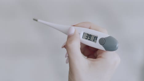 hand holding a digital thermometer