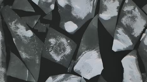 drone shot flying over frozen lake covered in ice and snow flying passed chunks of ice
