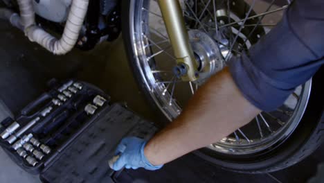 Male-mechanic-repairing-motorbike-in-repair-garage-4k