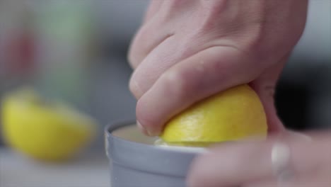 persons fingers squeezing the lemon juice out of the lemon