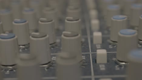 súper primer plano de las perillas del mezclador de audio gris