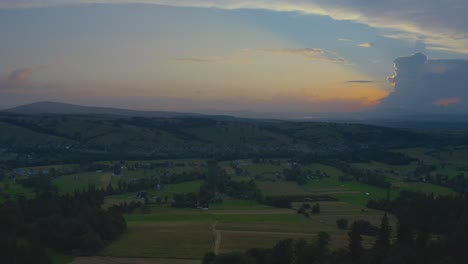 Sunset-over-countryside-trees-and-green-fields---drone-aerial