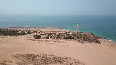 historic cape trafalgar lighthouse with sandy beach in summer in cadiz, spain