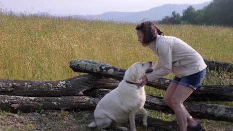 woman and white lab outdoors with mountain backdrop