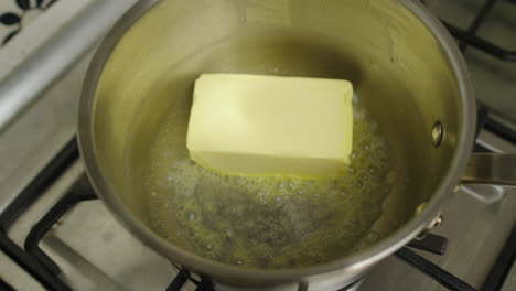 placing full pack of new zealand butter into hot cooking pot for melting