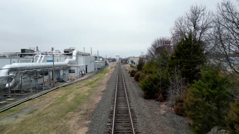 reverse aerial on of train track with factory in shot in kernsville nc