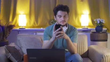 hombre deprimido en la noche enviando mensajes de texto por teléfono.