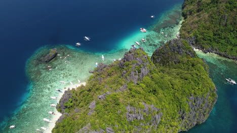 Cinematic-aerial-footage-of-the-trees-on-cliffs-in-Palawan-with-beaches-and-boats-in-view-on-a-clear-bright-sunny-day-in-the-Philippines,-Asia,-Drone