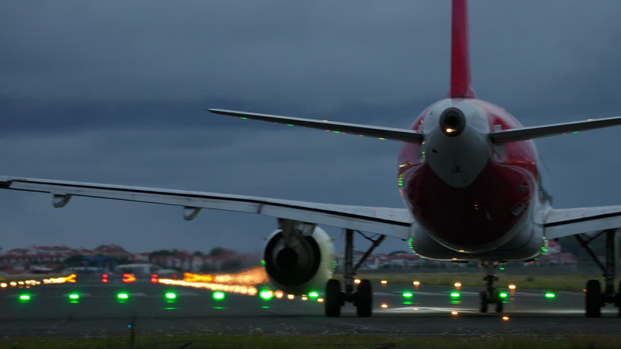 Airplane positioned on runway with illuminated lights in the background, capturing the essence of aviation and travel at dusk