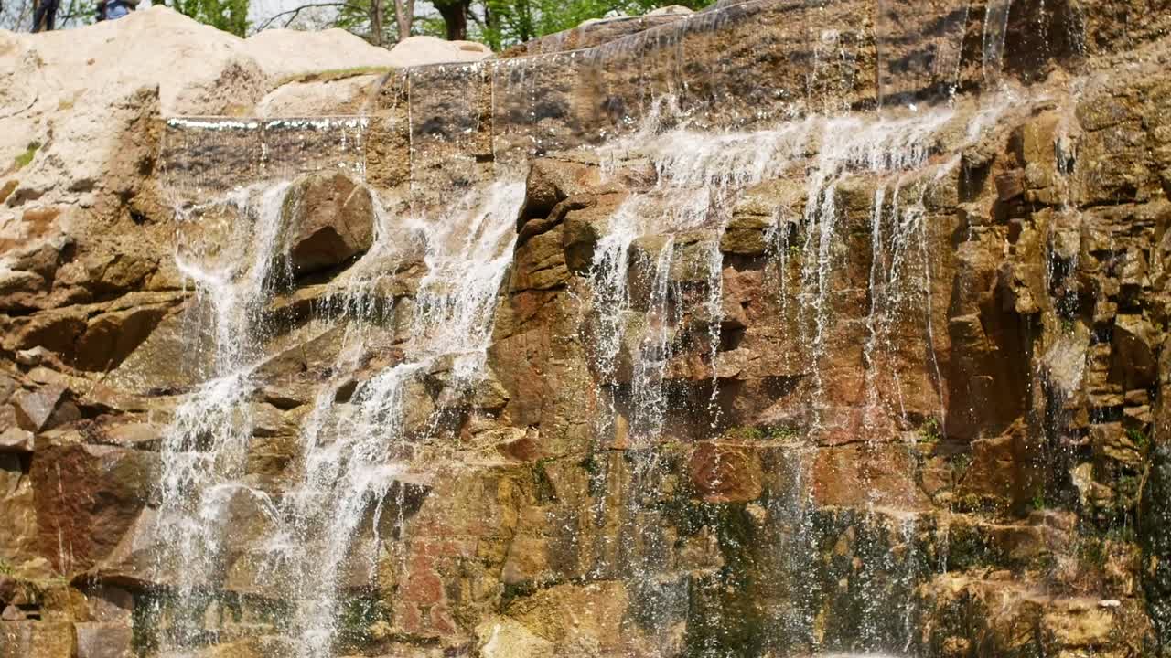 hermosa cascada desde un acantilado en el bosque. 4k video de agua que fluye, arroyo que fluye entre las piedras. arroyo en el bosque