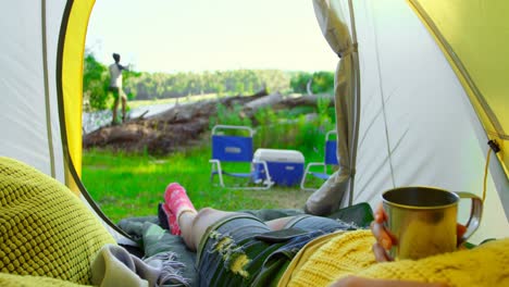 low section of woman relaxing in tent in the forest 4k