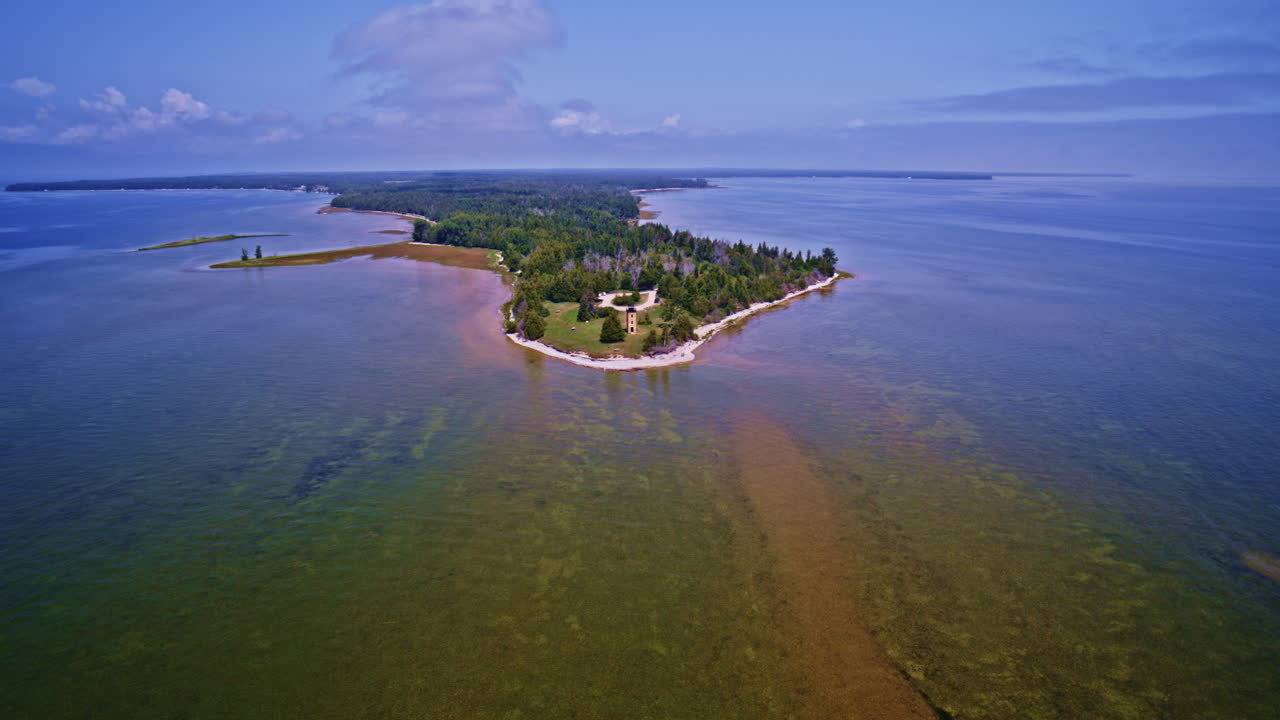 Drone footage showcasing a lighthouse at the far end of a Lake Michigan peninsula.