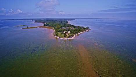 drone footage showcasing a lighthouse at the far end of a lake michigan peninsula.