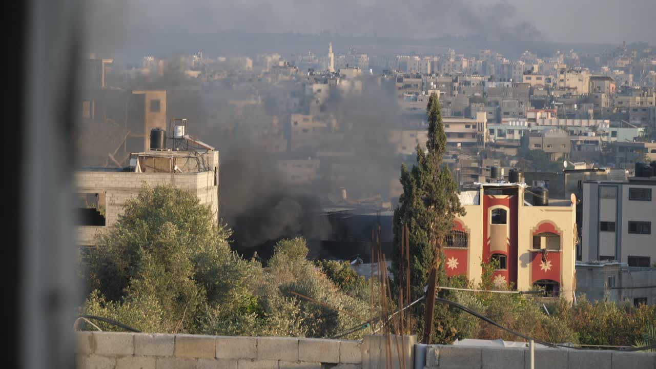 Thick black smoke rises high among buildings destroyed by Israeli missile attacks in Palestine
