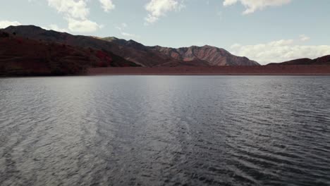 Low-flying-drone-over-lake-rises-to-reveal-the-mountain-ranges-in-Salt-Lake-City-Utah-at-60fps