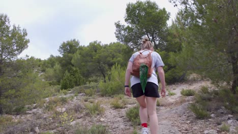 joven rubia haciendo senderismo en el bosque de las montañas de alcoi, españa, cámara lenta