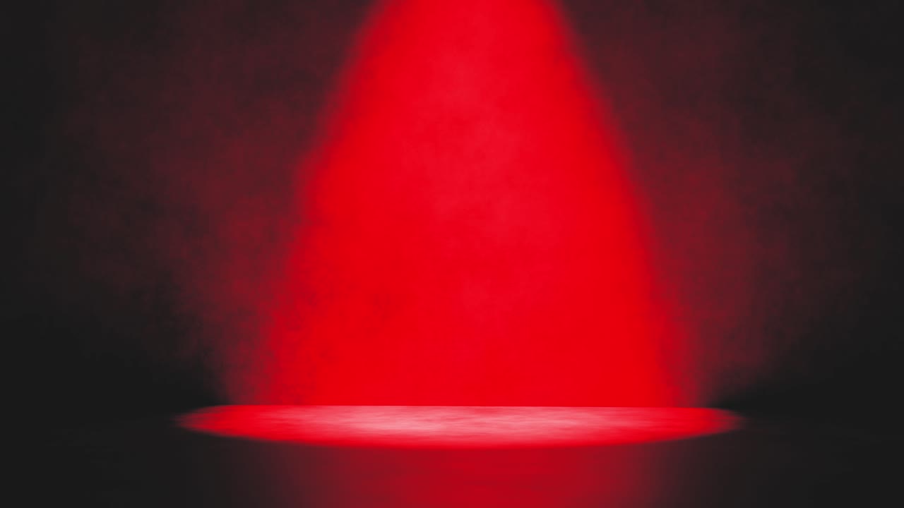 Drammatico fascio di luce rossa che illumina un palco fumoso