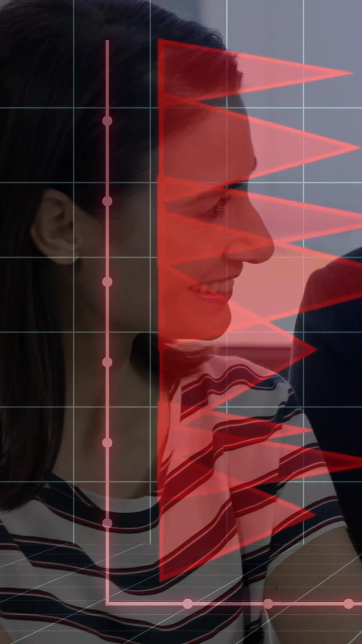 Video verticale: donna in ufficio che si gira ascoltando, con un'interfaccia HUD sovrapposta al viso che mostra bandiere rosse e una L rosa