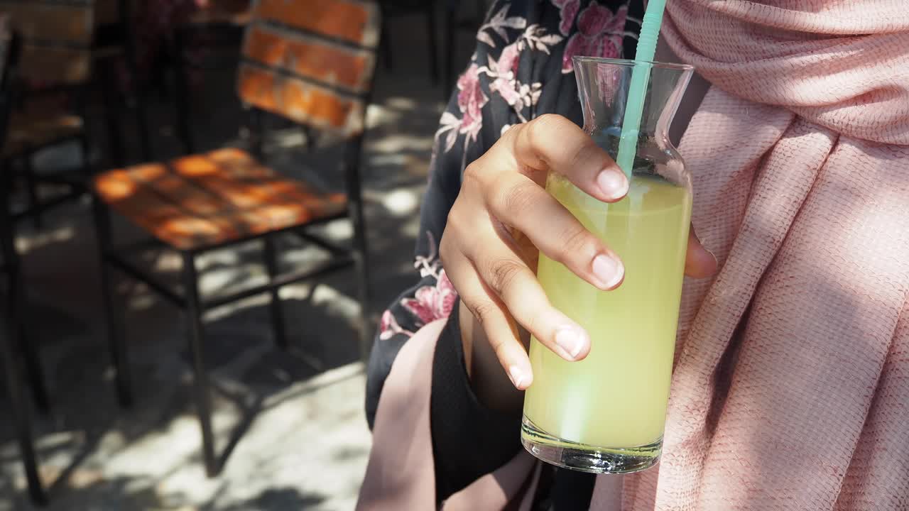 mujer disfrutando de una limonada en un café