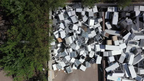 heaps of broken discarded household appliances dumped at disposal center, aerial